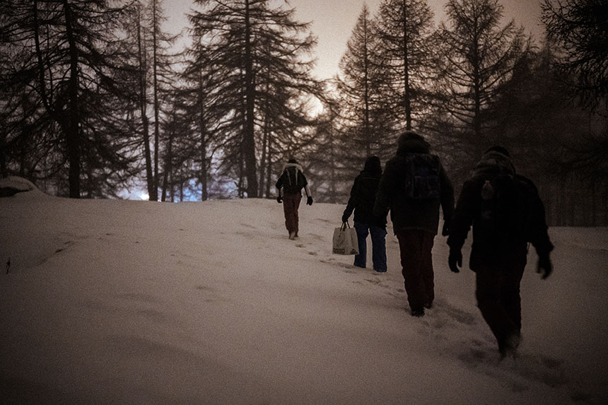 Groupe d'hommes marchant dans une forêt enneigée