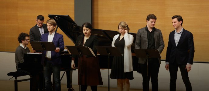 Chanteurs devant un piano