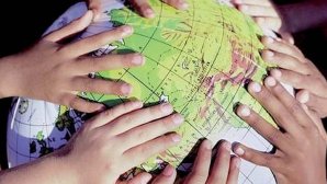 Gros plan sur des mains d'enfants posées sur un globe terrestre gonflable