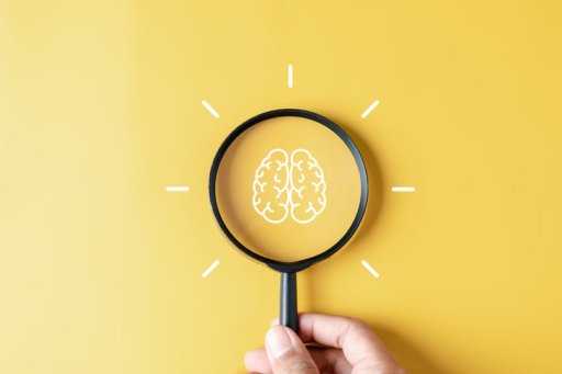 Magnifying glass drawing of a brain on a yellow background