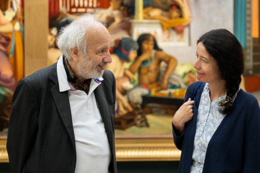 Deux personnes discutant devant un tableau