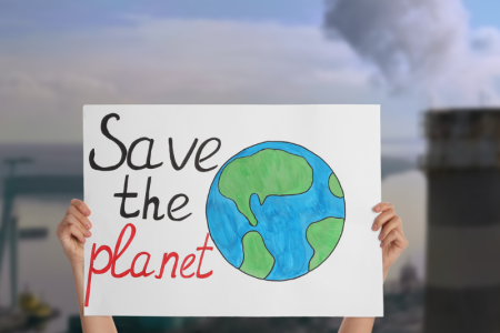 Pancarte tenue à deux mains avec le slogan "Save the planet" et le dessin d'une terre