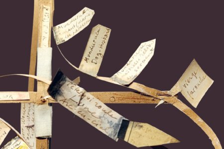 Détail d’un montage en papier avec notes manuscrites fixées sur des tiges