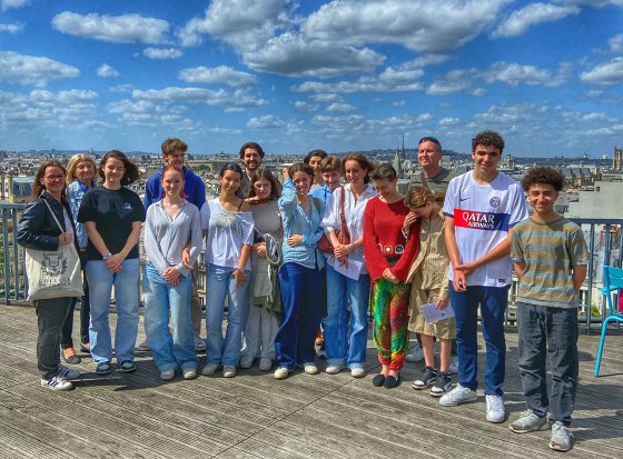A group of middle and high school students on a guided tour of the Collège de France
