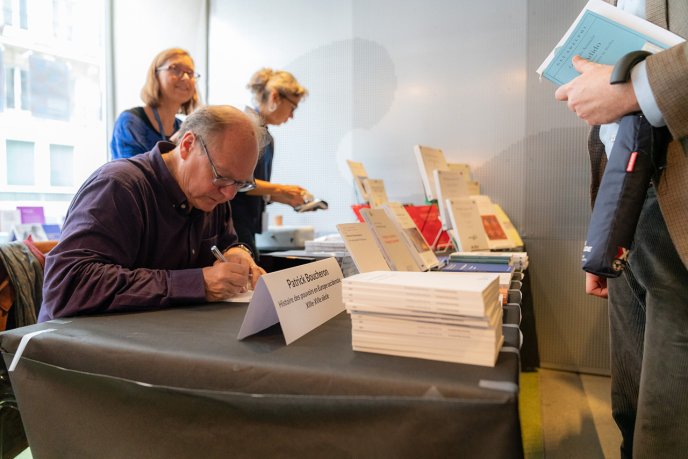 Pr William Marx writing a dedication during the JEP 2024