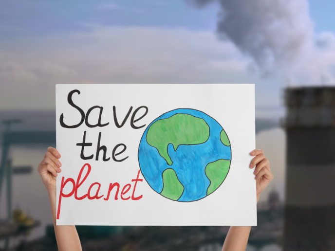 Pancarte tenue à deux mains avec le slogan "Save the planet" et le dessin d'une terre