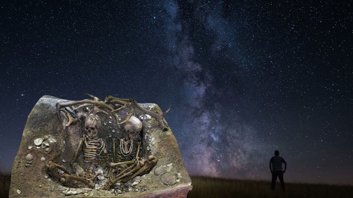 Deux squelettes humains et la silhouette d'un homme sur fond de ciel étoilé