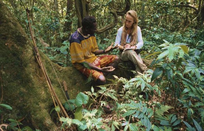 Deux personnes assises dans une forêt en train de discuter