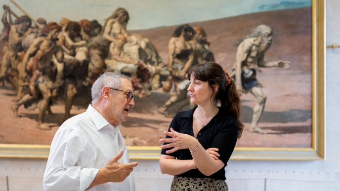 Deux personnes discutant devant un tableau