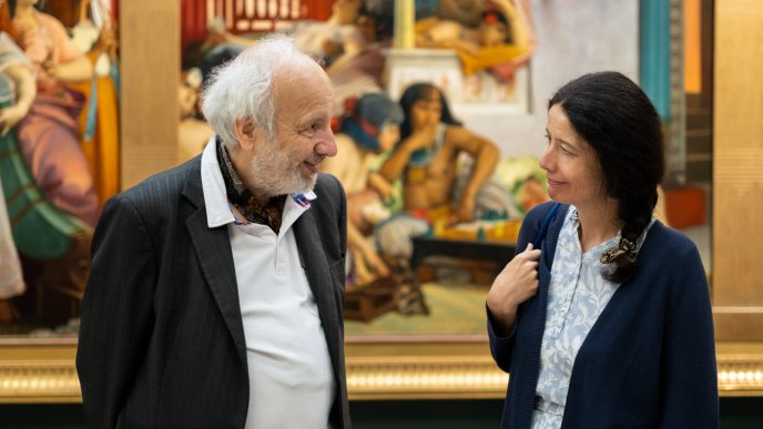 Deux personnes discutant devant un tableau