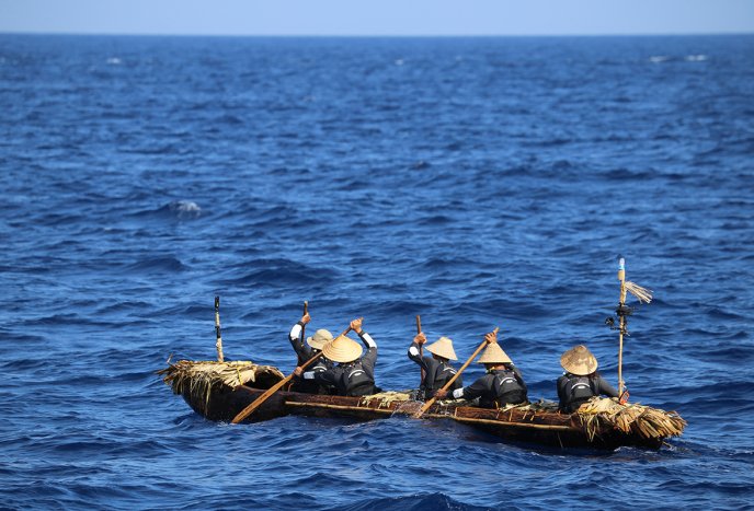 Afficher l'image en plein écran : Photo de cinq personnes pagayant dans une barque sur la mer