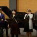 Singers in front of a piano