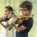 Deux jeunes enfants jouant du violon