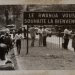 Photographie en noir et blanc avec personnes dans la rue et panneau "Le Rwanda vous souhaite la bienvenue" (Photographie décrite dans le Convoi de Beata Umubyeyi Mairesse, Flammarion, 2024)