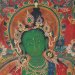 Peinture traditionnelle tibétaine (thangka) représentant une divinité bouddhiste à la peau verte, entourée de motifs floraux et ornementaux richement colorés.