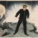 Estampe japonaise de style ukiyo-e montrant un officier naval debout sur un pont en feu, au milieu d’explosions, dans une scène héroïque de bataille
