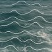 Surface de l’océan vue d’en haut, avec des vagues bleu-vert sur lesquelles sont superposées des lignes blanches ondulées, parallèles, évoquant le mouvement de la mer
